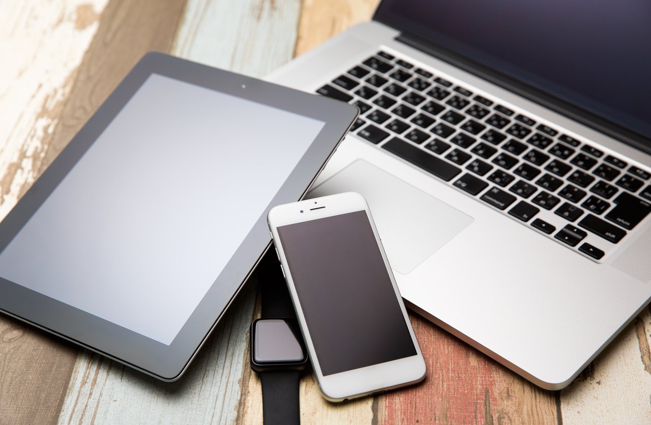 Tablet, Handy und Laptop liegen auf einem Tisch